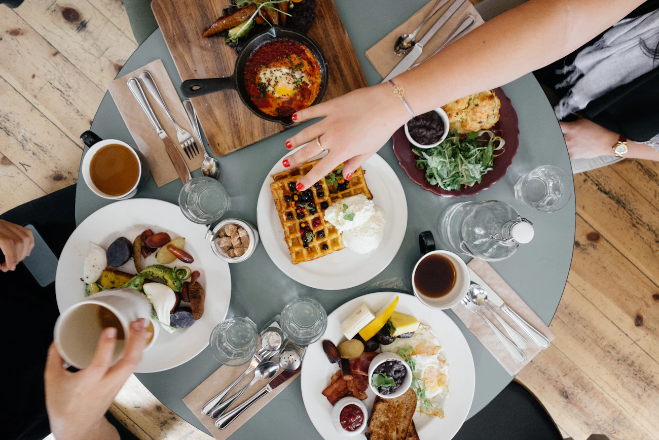 Hands sharing small plates across a table