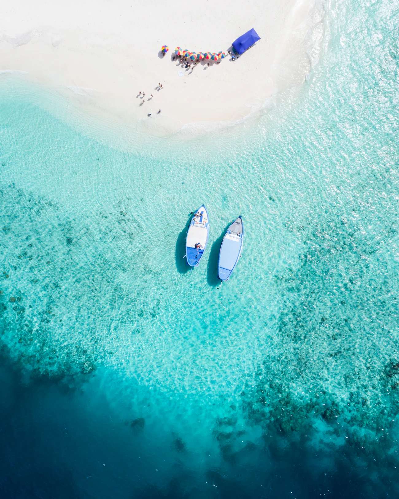 Two boats at anchor on clear turquoise water