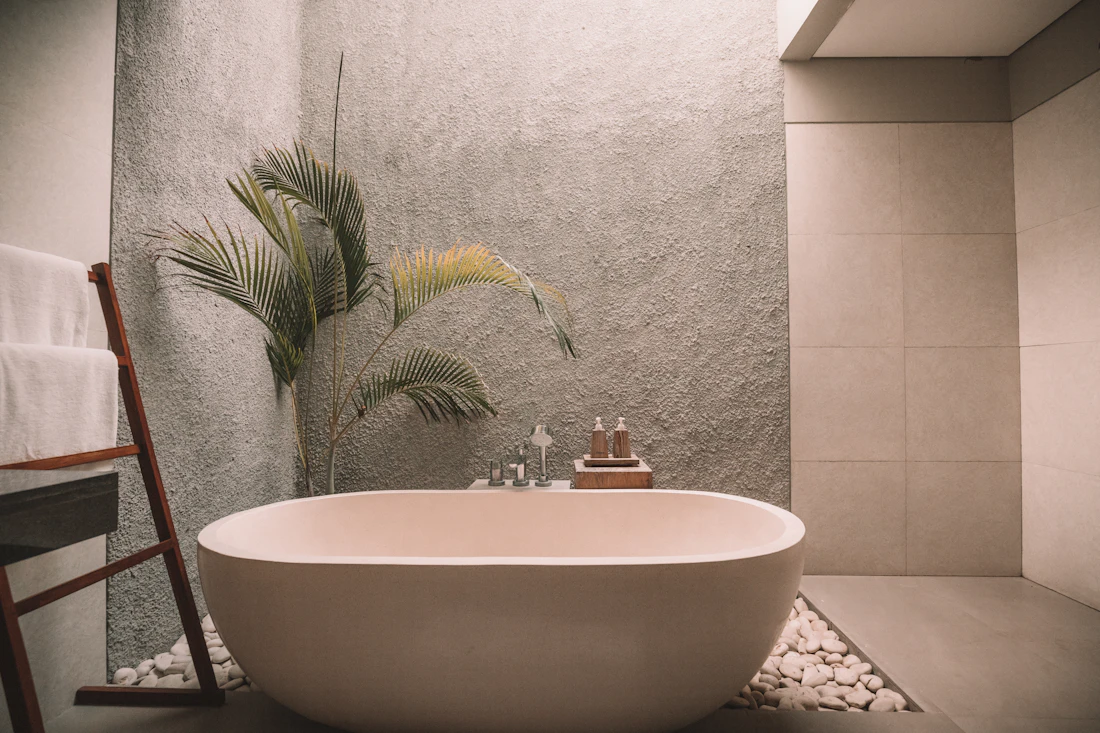 A freestanding bath in a quiet stone room