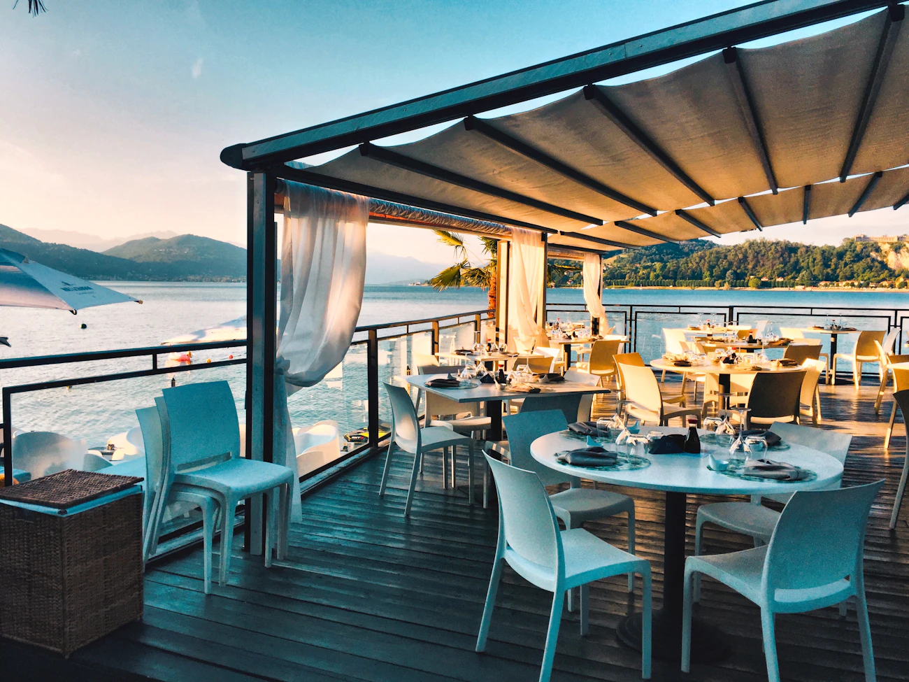 A curtained terrace table set above the water
