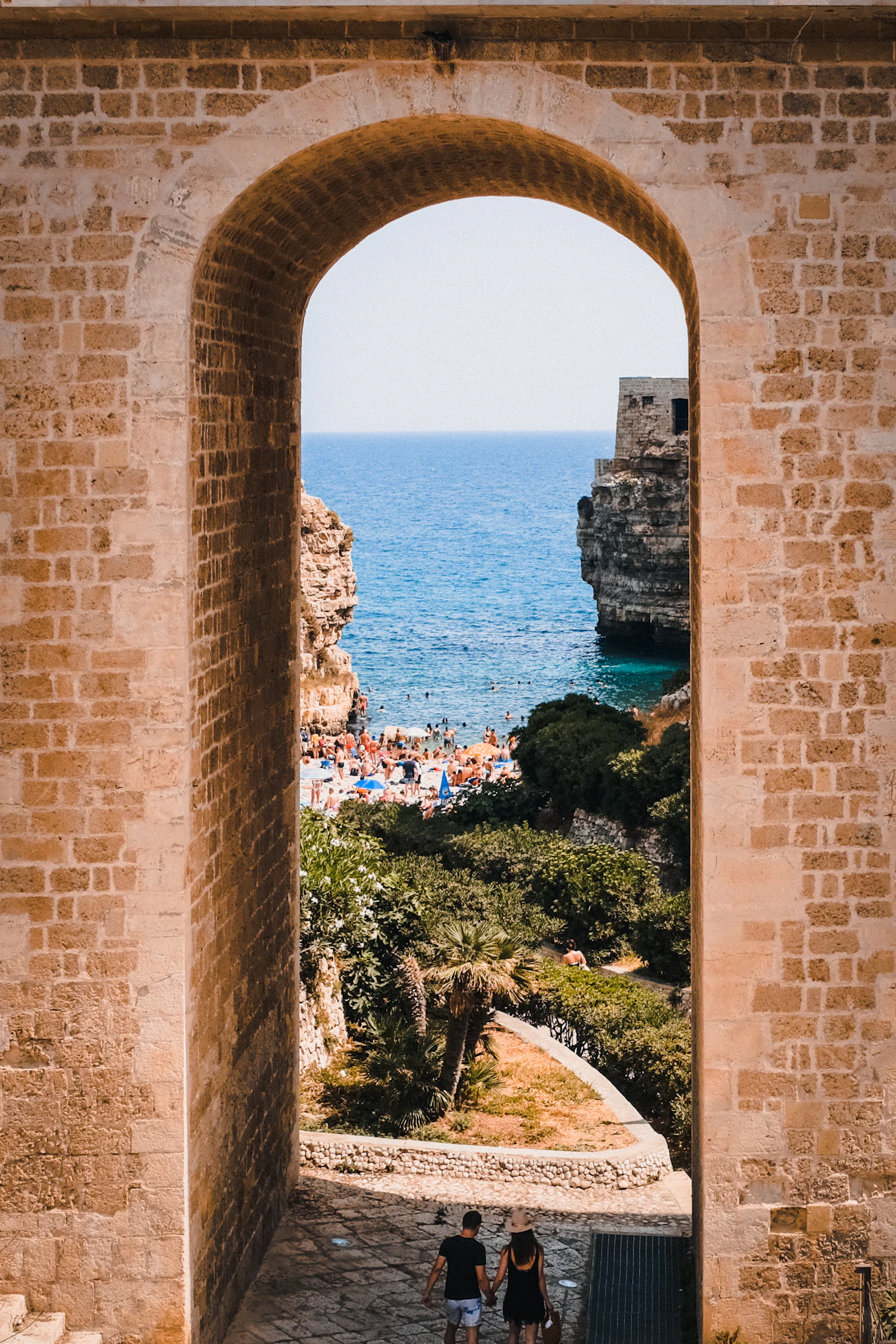 A sunlit cove framed by warm stone