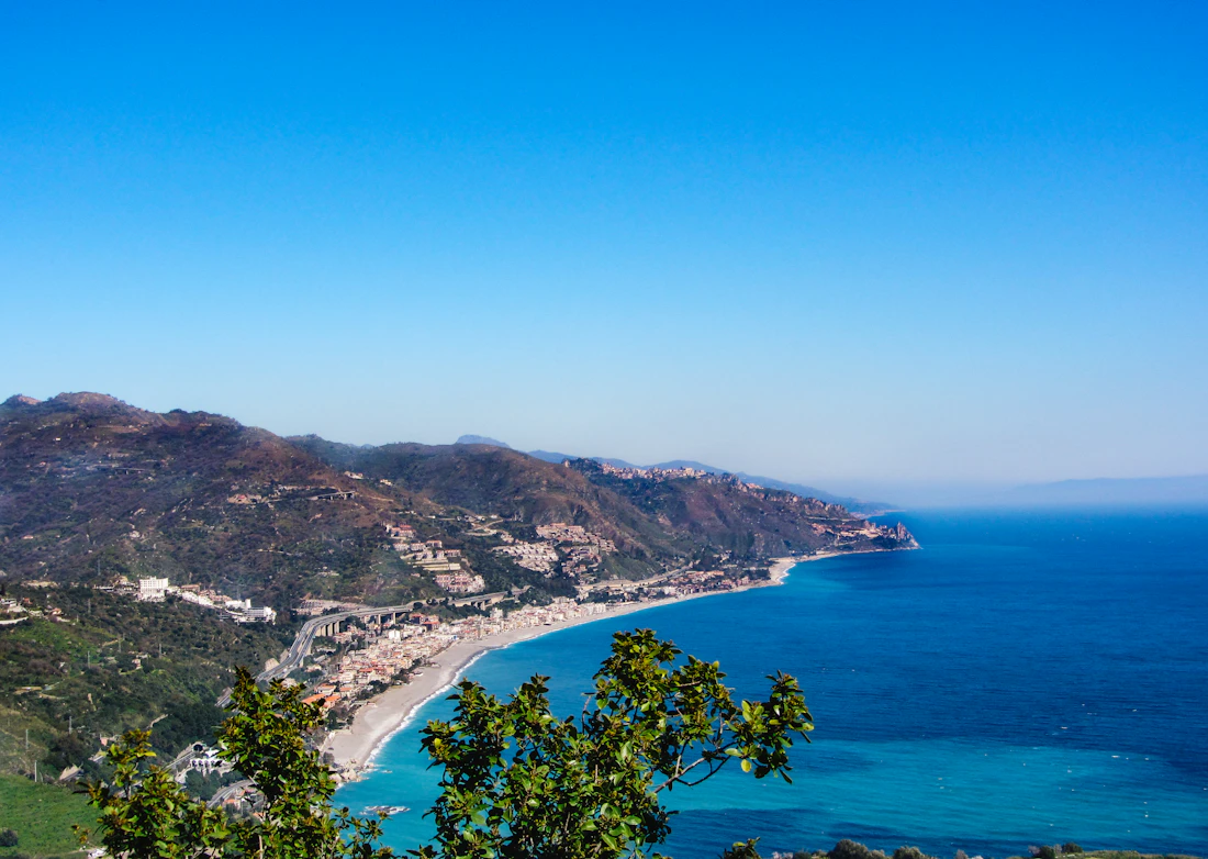 The Sicilian coastline curving along a wide blue bay