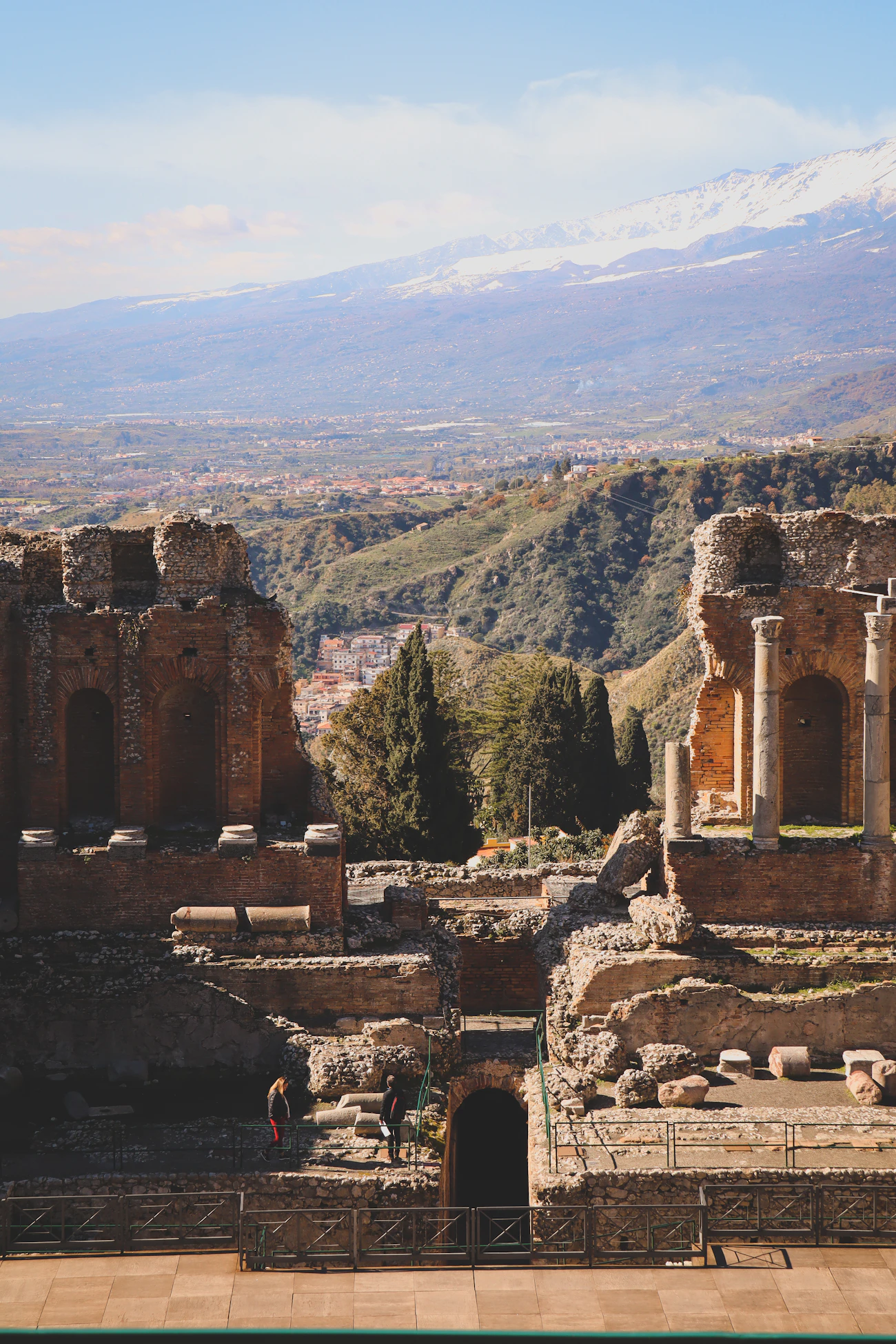 Greek theatre ruins with Mount Etna behind them